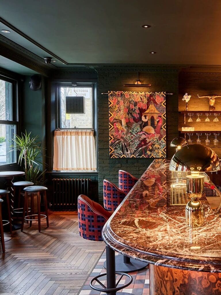 Tapestry’s bar area with warm lighting, bottles lined up and brunch cocktails on the counter, a Hove girls’ weekend spot with “one more drink” energy.