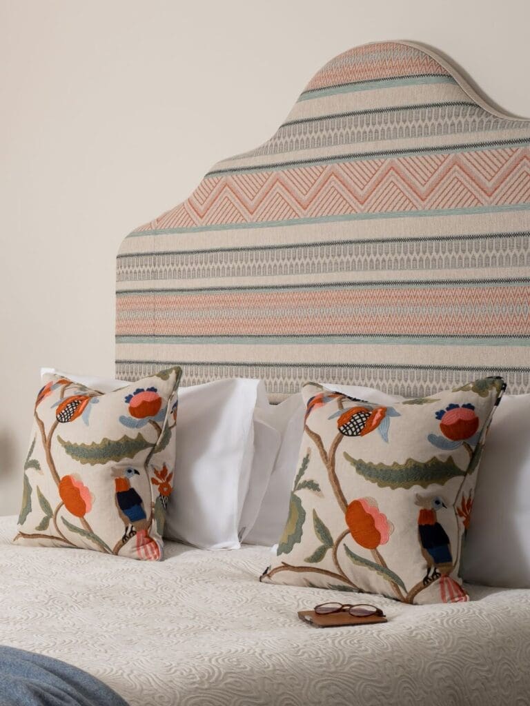 Close-up of crisp white bedding and upholstered headboard in a Royal Crescent bedroom.