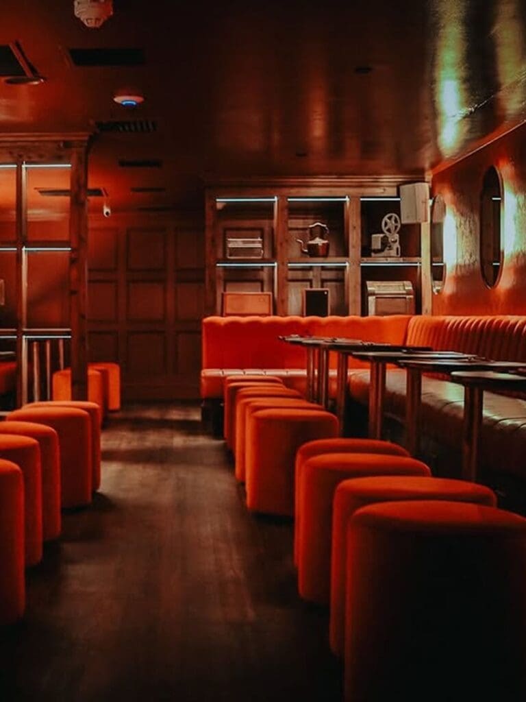 Interior of RADIO Glasgow with low-lit red booths and intimate cocktail bar seating
