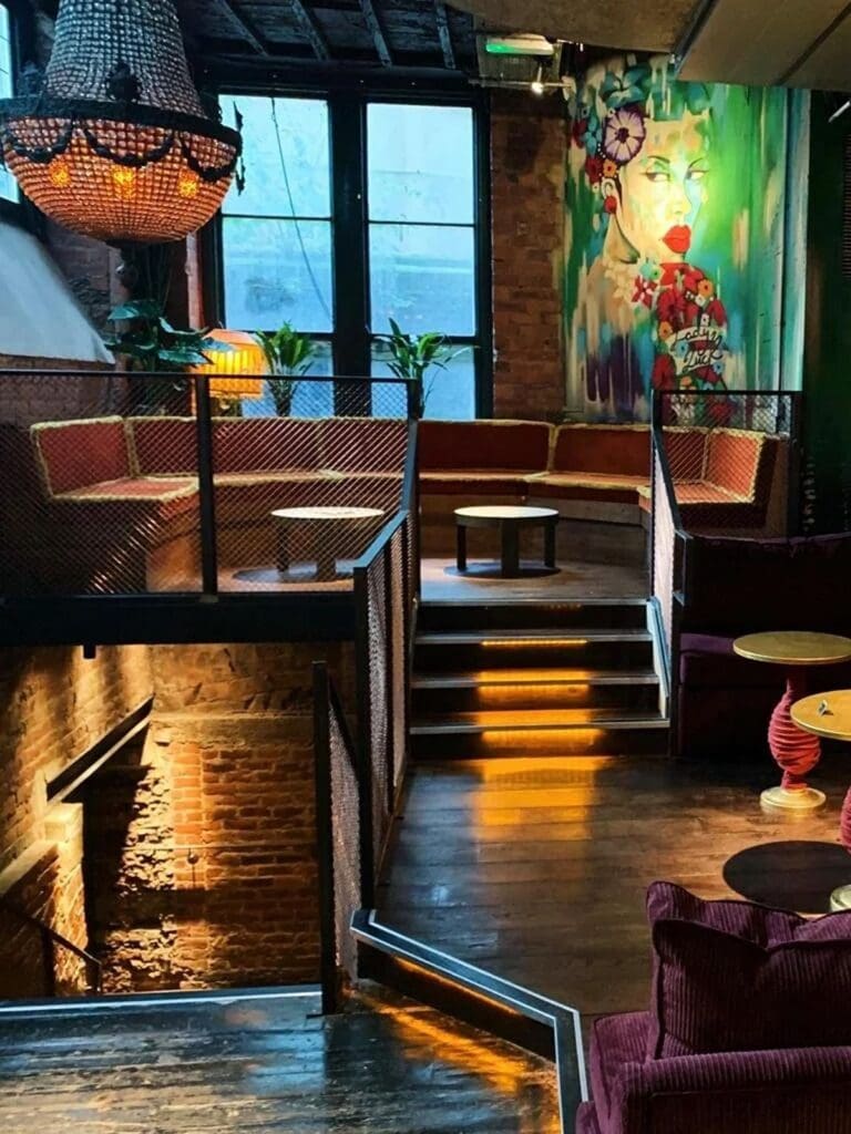 Dark, buzzy function room with stage lighting and banquet-style tables set up for a Newcastle hen weekend brunch.