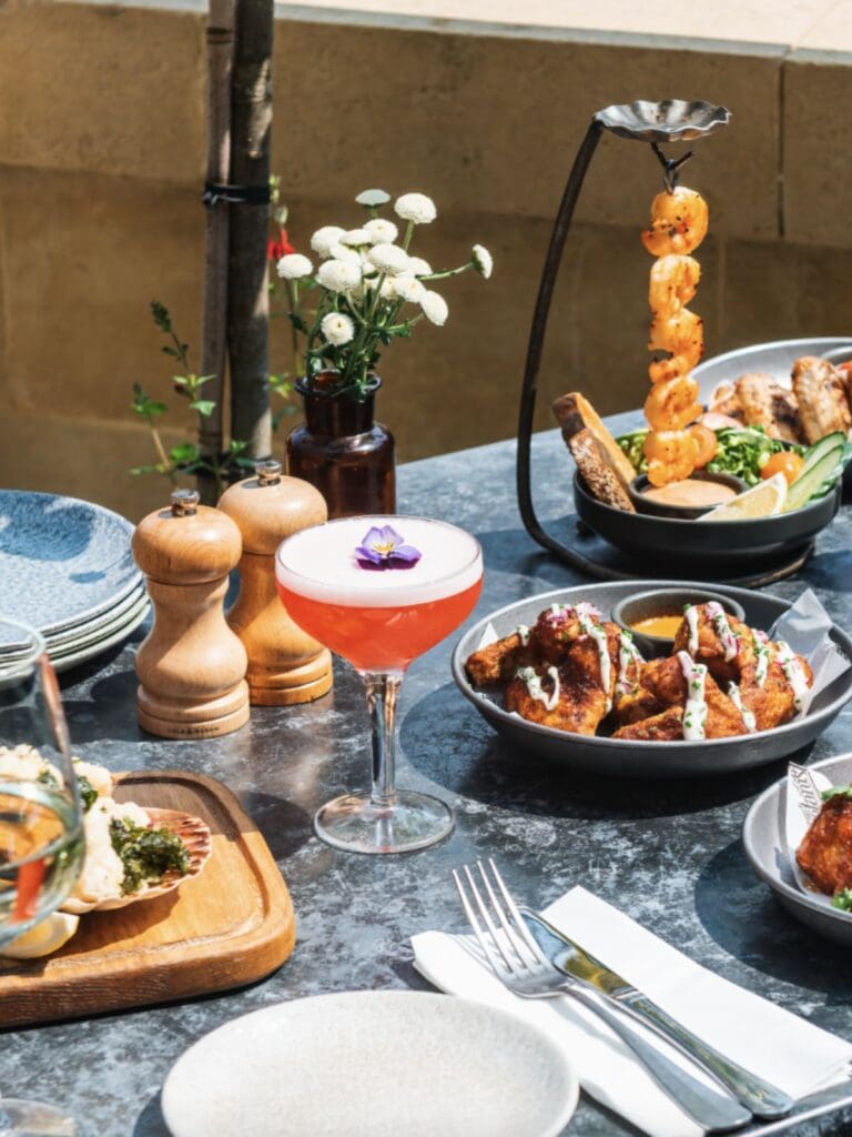 Close-up of brunch plates and espresso martinis at The Botanist, hands mid-cheers, the kind of hen weekend start that means business.
