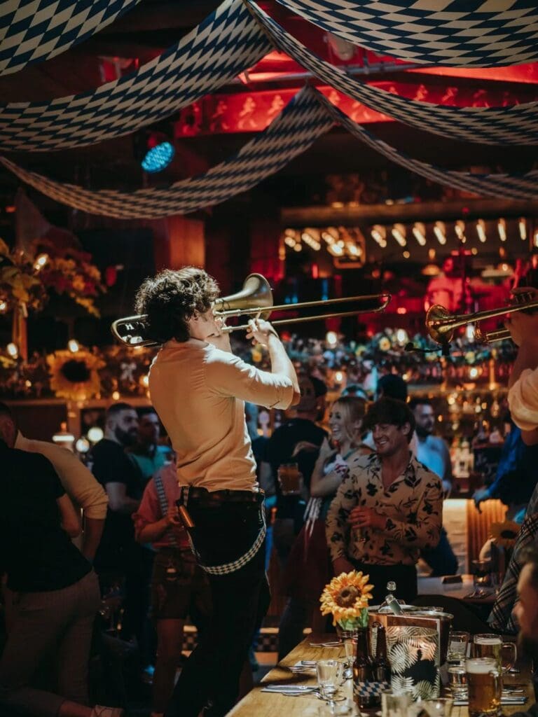 Trombone players performing inside Brewhemia Edinburgh as guests dance and drink during a vibey girls’ night dinner.