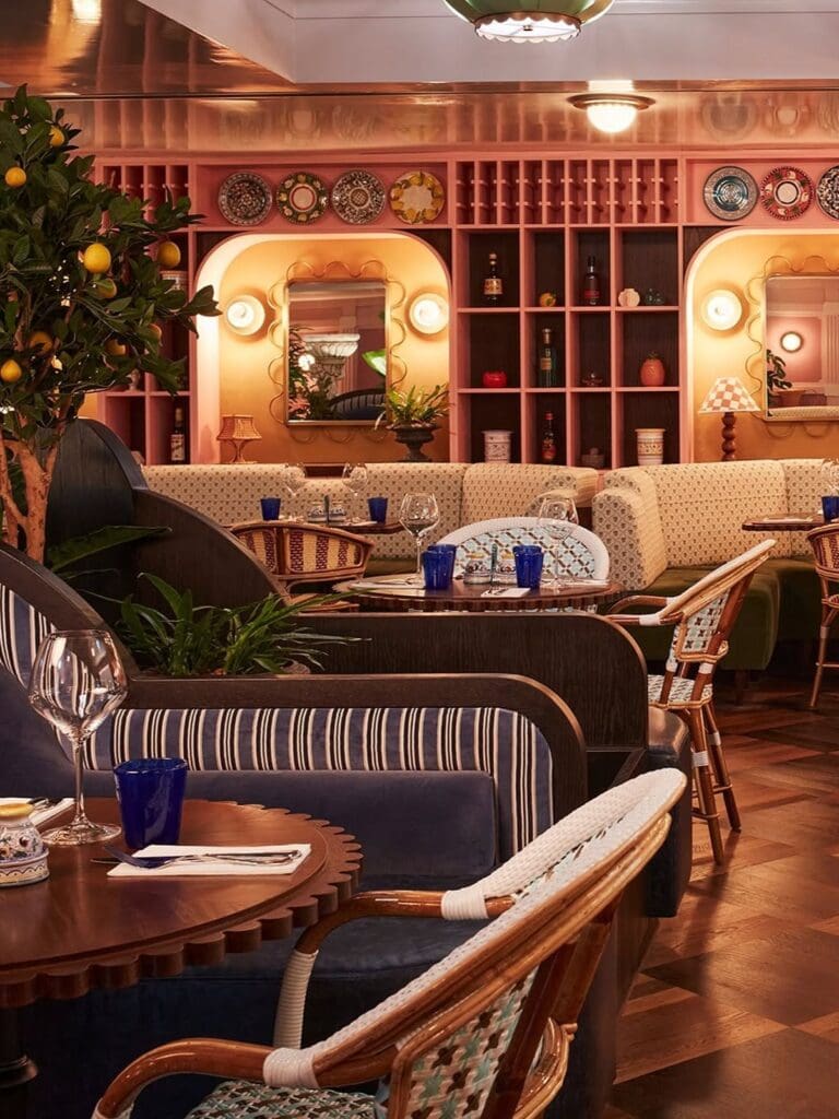 Colourful dining room at Patatino Edinburgh with pink shelving, patterned plates and cosy booth seating for a hen party dinner.