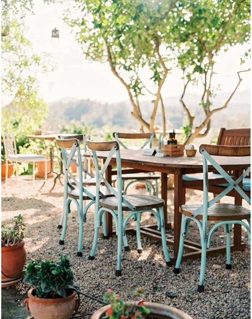Outdoor garden seating at La Paloma Café in Ibiza, rustic tables and chairs under trees for a relaxed daytime lunch.