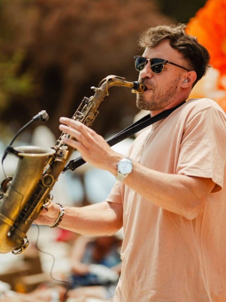 Live saxophonist performing at Nikki Beach Ibiza during a daytime brunch club event.