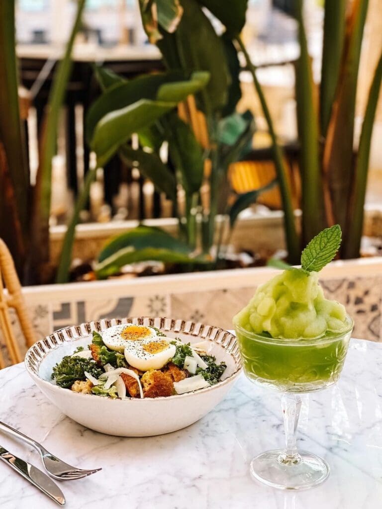 Brunch plates and a frozen green cocktail at Passion Café in Ibiza, set on a sunlit terrace.
