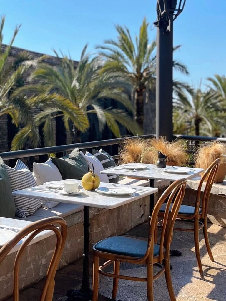 Sun-drenched terrace seating at Café Poupette overlooking Sa Feixina Park in Palma, ideal for a laid-back hen weekend brunch.