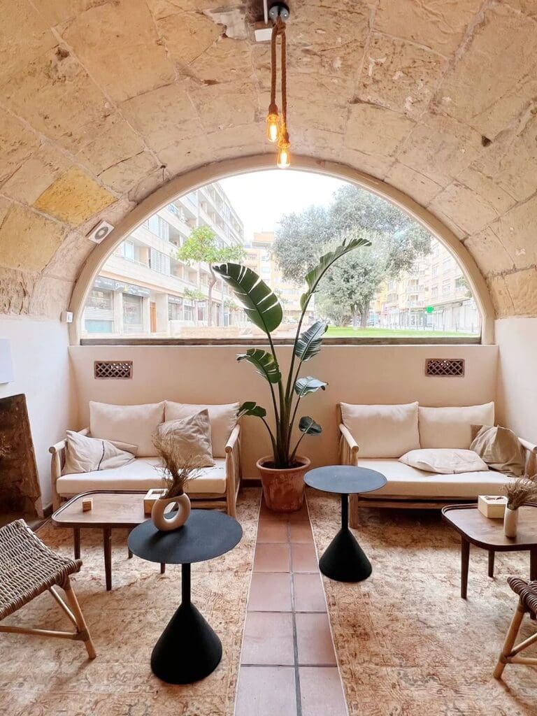 Neutral-toned interior at Santal in Santa Catalina, Palma, with arched stone ceilings and relaxed seating, a cool-girl brunch spot for a hen weekend.