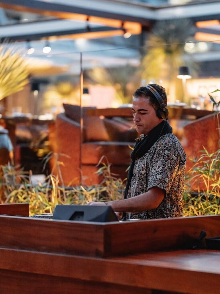 DJ playing music at Zuma Ibiza’s stylish outdoor terrace, setting the vibe for a fun and glamorous hen party dinner in Ibiza.