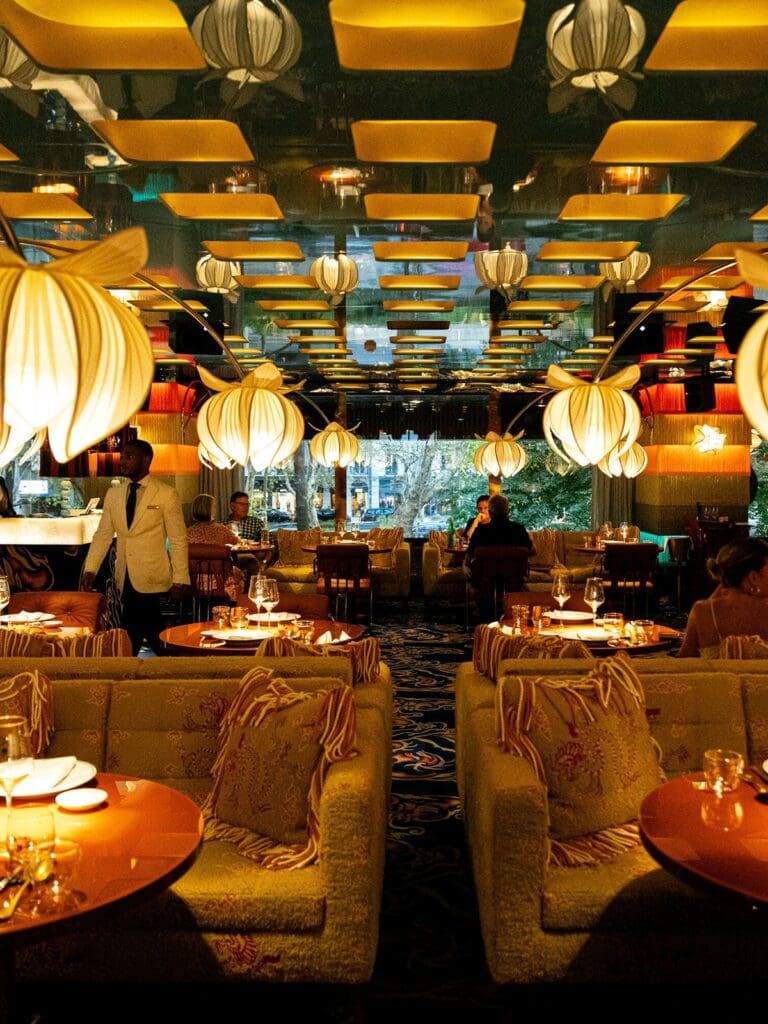 Luxe interior at JNcQUOI Frou Frou in Lisbon featuring dramatic lighting and statement booths for a girls’ night out.