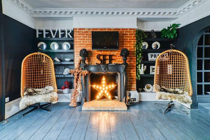 Stylish eclectic Brighton Airbnb apartment with exposed brick fireplace and lounge seating, perfect for hen party stays in Kemptown