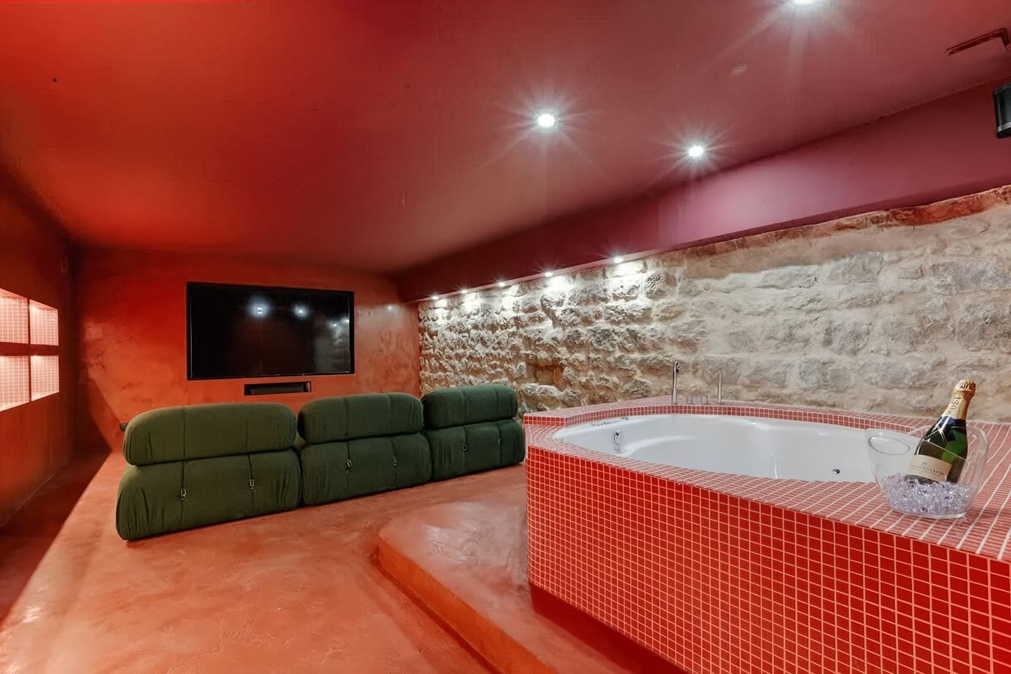 Basement cinema and jacuzzi room in Les Halles Paris apartment with red interiors and built-in spa bath for hen weekends in Paris