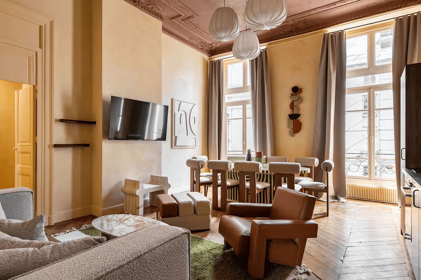 Central Paris apartment with open-plan kitchen and dining area, alongside modern bedroom with neutral tones and comfortable bedding