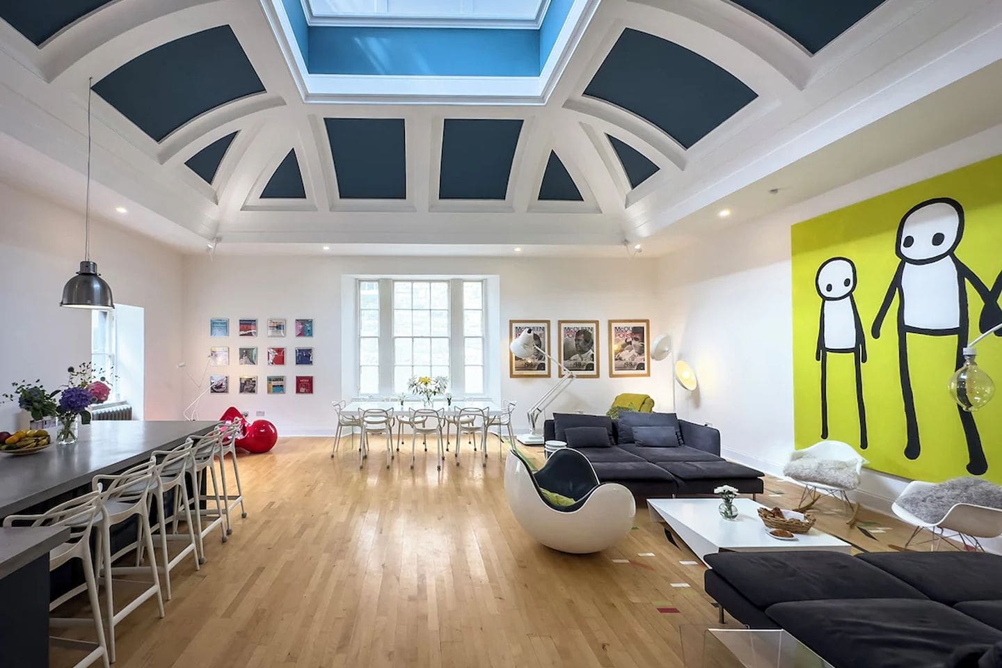Large open-plan living space in Edinburgh Old Gym House with vaulted ceiling, skylight and long dining table, ideal for big group stays