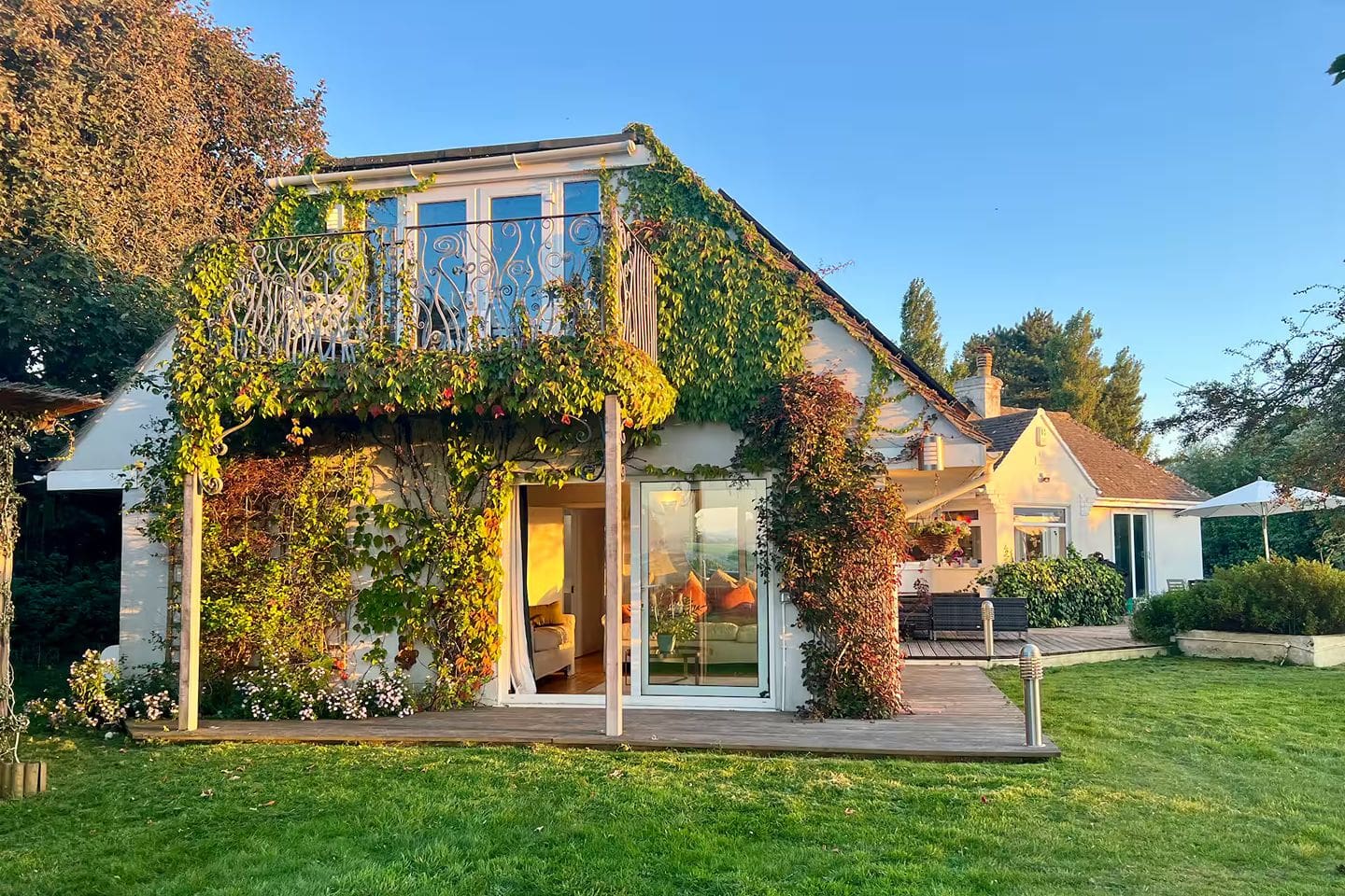 Exterior of a countryside Airbnb near Brighton covered in greenery, with a large house set in the South Downs, ideal for a relaxed hen weekend getaway
