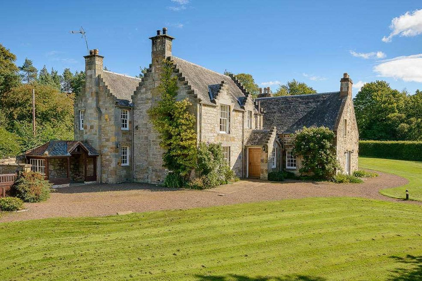 Charming countryside cottage at Winton Estate near Edinburgh with expansive lawn and traditional Scottish stone exterior