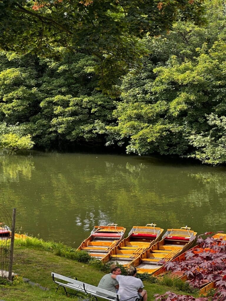 Traditional wooden rowing boats lined up beside the river in Bath, a scenic outdoor option for groups looking for relaxed Bath hen do activities