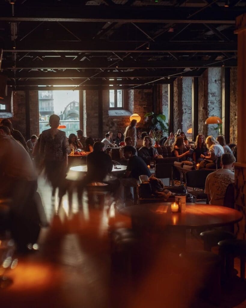 Low-lit bar at Daphne in Dublin, with warm table lamps, a busy evening crowd and relaxed cocktail-bar energy for a girls’ night out in Dublin.
