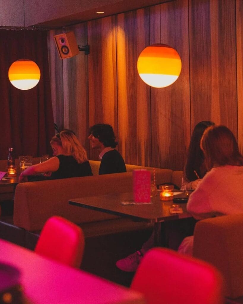 Warm, low-lit seating inside L’Aperitivo in Liverpool, with glowing pendant lights, wood-panelled walls and a relaxed aperitivo-bar feel for a girls’ night out in Liverpool.
