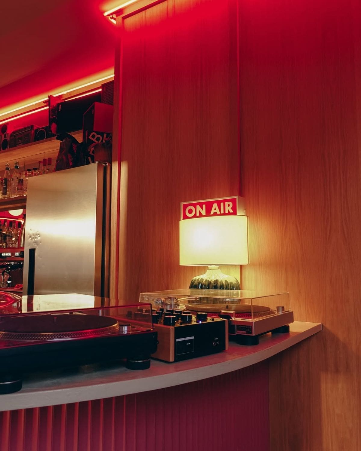 Turntables and a glowing On Air lamp inside Sister Ray in Liverpool, with red lighting and listening-bar details for a cool girls’ night out in Liverpool.
