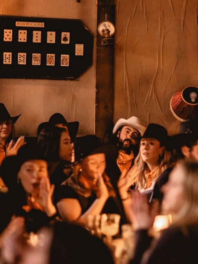 Guests in cowboy hats and neck scarves enjoy an immersive Wild West cocktail experience at Moonshine Saloon, a lively option for Liverpool hen do activities.