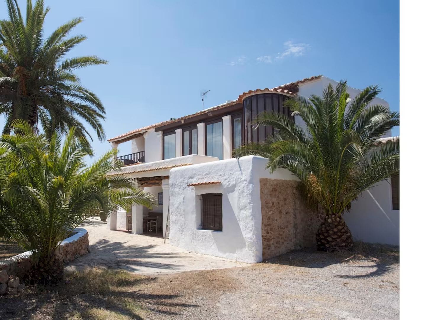 Rustic finca with wooden beams, eclectic interiors and shaded outdoor dining in Airbnbs in Ibiza for a hen weekend.