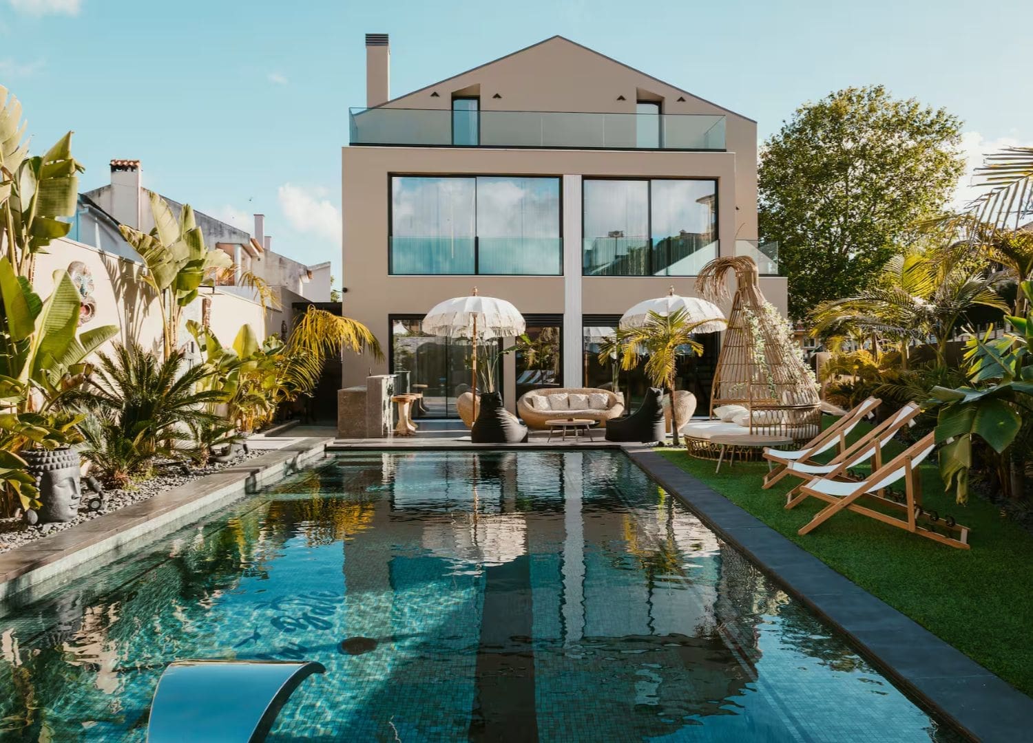 Modern coastal villa with sun-soaked pool, loungers and outdoor dining space in Airbnbs in Lisbon for a hen weekend.