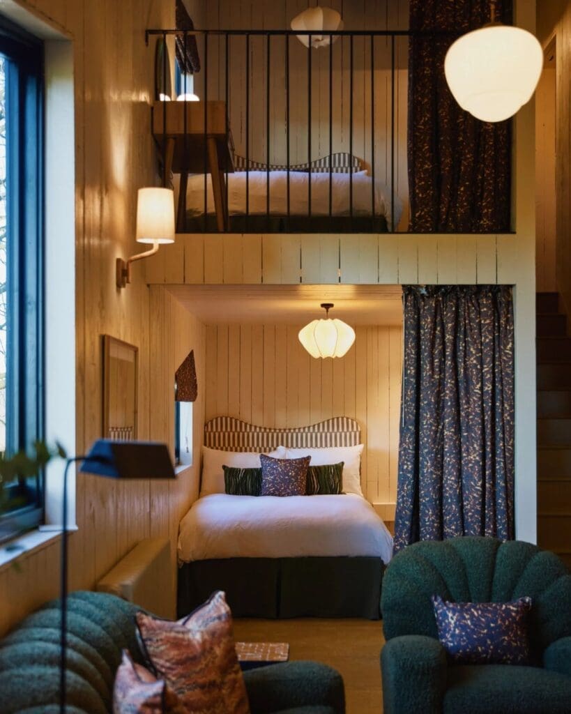 Double-height cabin interior at Bonnington Farm with layered sleeping spaces, warm lighting and design-led countryside interiors — a stylish retreat for a quieter hen weekend or girls’ getaway.