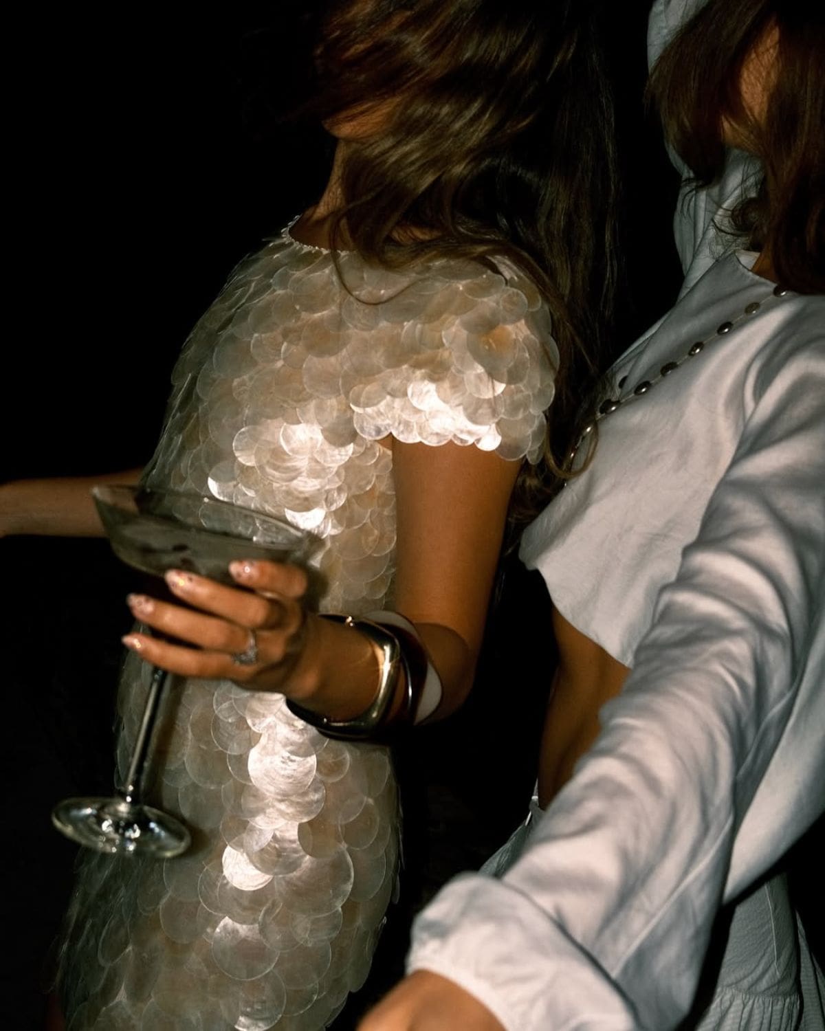 Two women dressed for a night out, one holding a martini glass in a shimmering sequin dress — a stylish cover image for where to go out-out in Dublin on a hen weekend or girls’ trip.