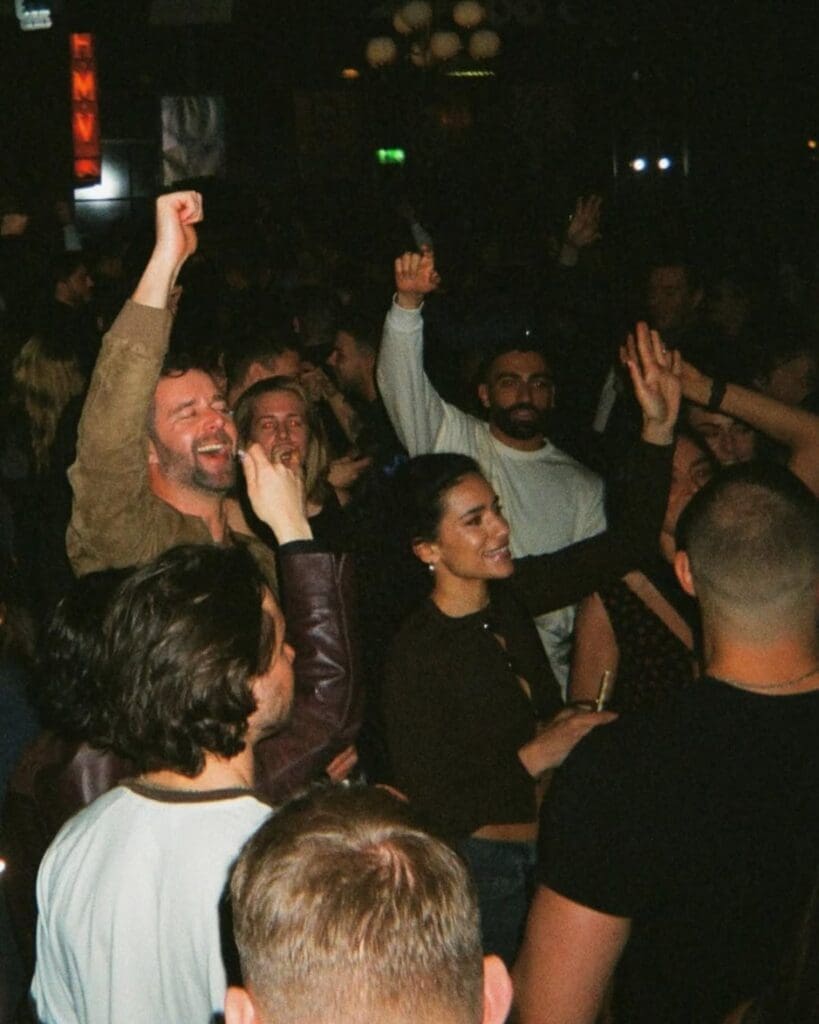 A packed crowd dancing at The Freemount in Manchester, arms in the air and drinks in hand — a lively late-night bar for going out-out on a Manchester hen weekend.