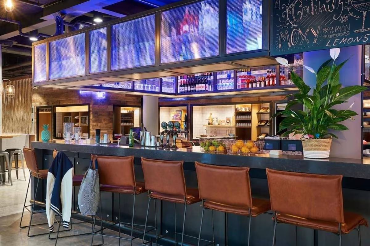 Bar area at Moxy Dublin City, a fun Dublin hen weekend hotel with neon lighting, cocktails and sociable seating.