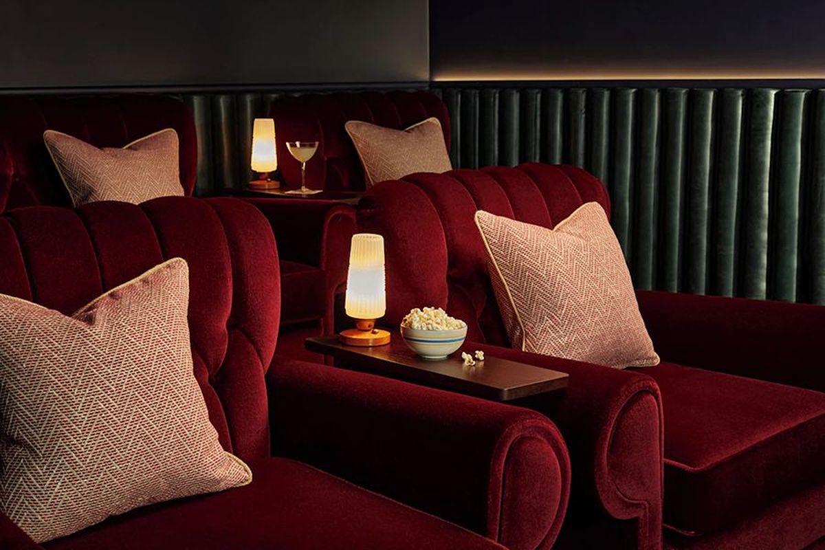 Plush cinema room at The Hoxton Edinburgh, an Edinburgh hen weekend hotel with deep red seating and a cosy, luxurious atmosphere.