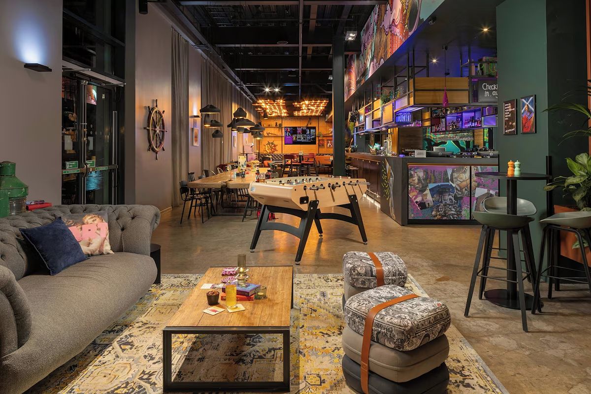 Communal lounge at Moxy Glasgow Merchant City, a sociable Glasgow hen weekend hotel with colourful seating, workspaces and contemporary décor.