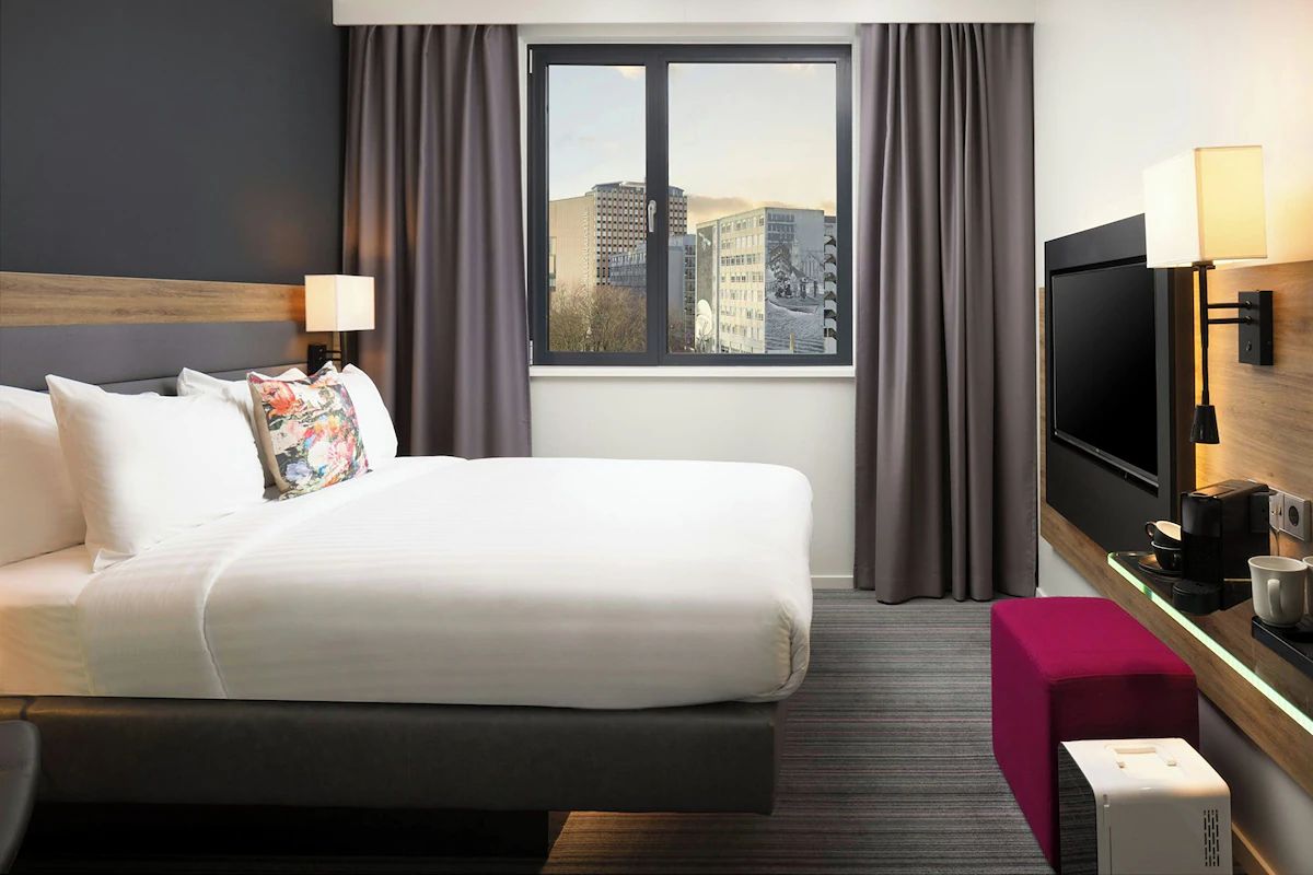Bright guest room at Moxy Glasgow Merchant City, a Glasgow hen weekend hotel with modern furnishings, large windows and practical city-centre comfort.