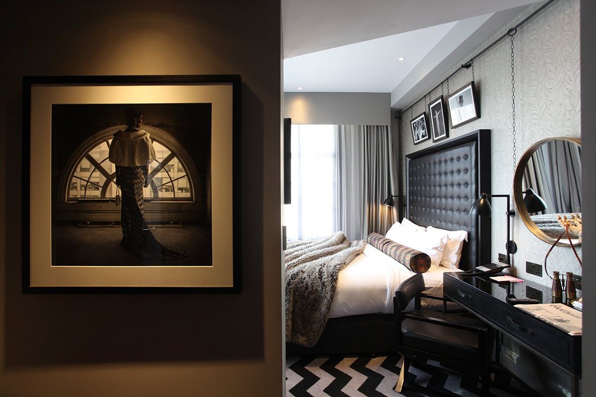 Bedroom at The Rex Newcastle with a statement headboard, dressing area and bold black-and-white interiors.