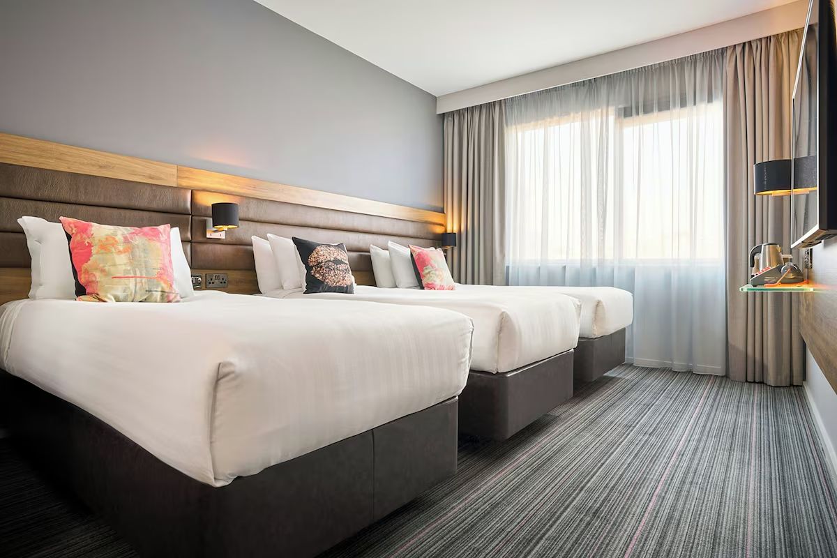 Twin room at Moxy Dublin City, a modern Dublin hen weekend hotel with two double beds, soft lighting and playful accent cushions.