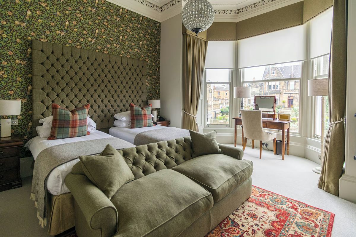Spacious twin bedroom at The Roseate Edinburgh, an Edinburgh hen weekend hotel with tall bay windows, elegant décor and comfortable group-friendly sleeping space.