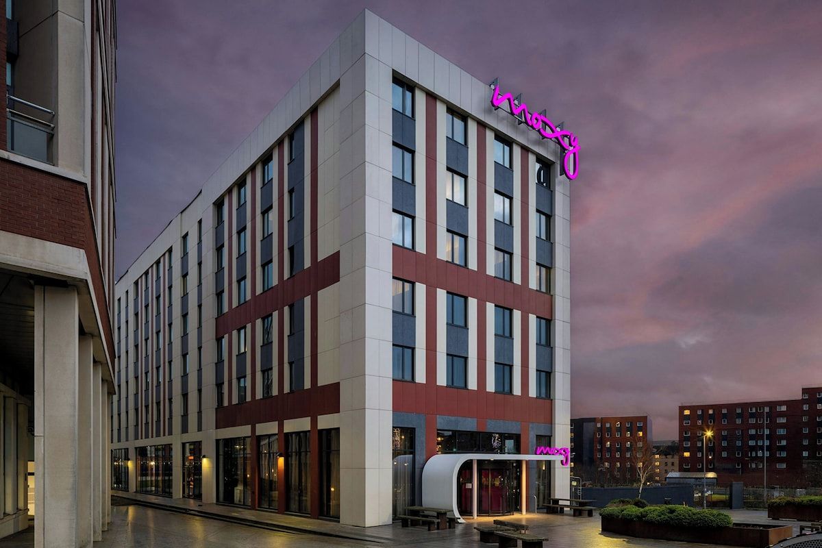 Exterior of Moxy Glasgow Merchant City, a modern Glasgow hen weekend hotel with bold neon signage in a central Merchant City location.