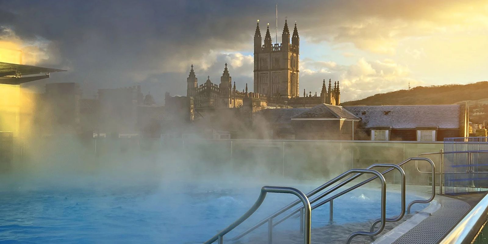 Rooftop thermal pool at Thermae Bath Spa overlooking Bath Abbey, a relaxing Bath hen weekend spa experience at sunset.