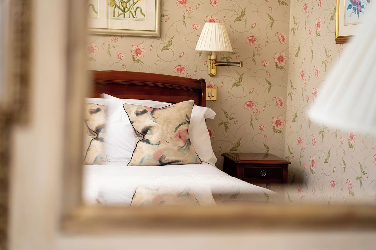Bright double bedroom at Dukes Bath with elegant furnishings and floral details.