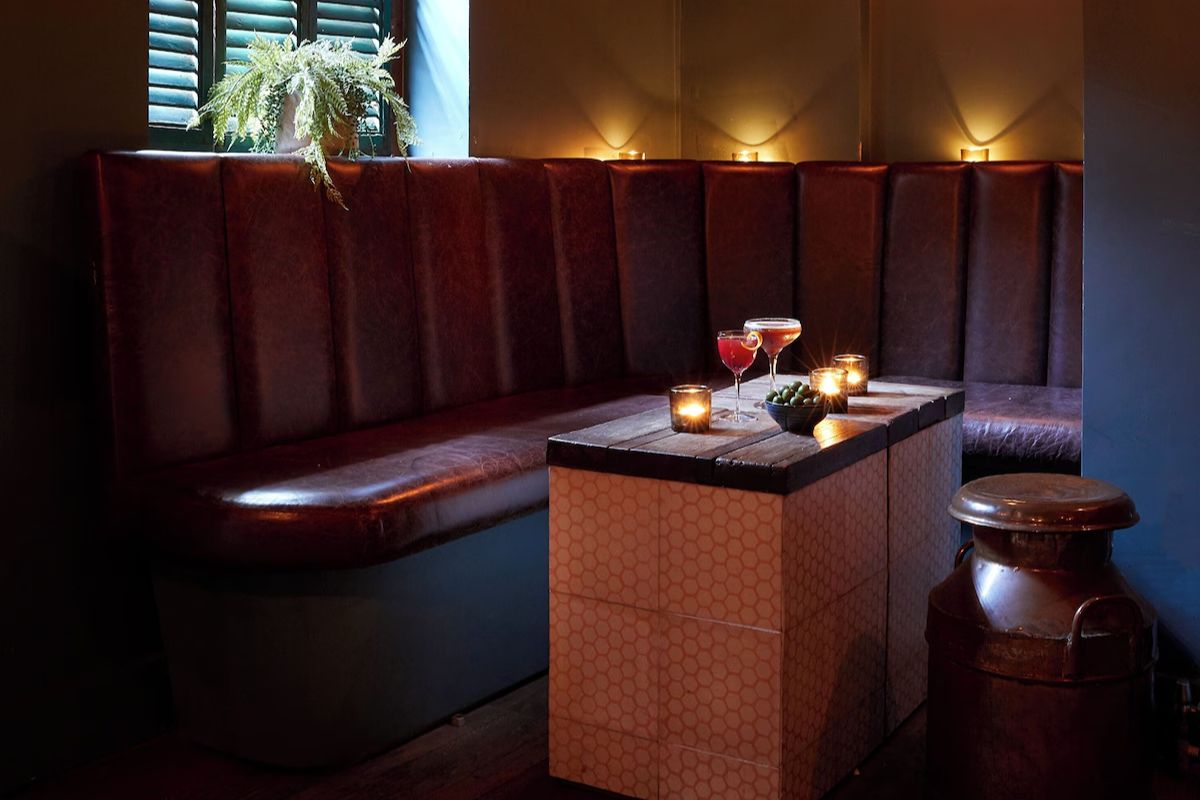 Intimate bar seating at Artist Residence Brighton, a quirky Brighton hen weekend hotel with dark interiors, candlelight and cocktails.