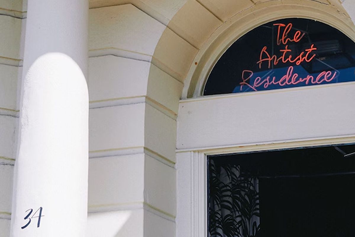 Entrance to Artist Residence Brighton, a boutique Brighton hen weekend hotel with a distinctive neon sign and characterful exterior.