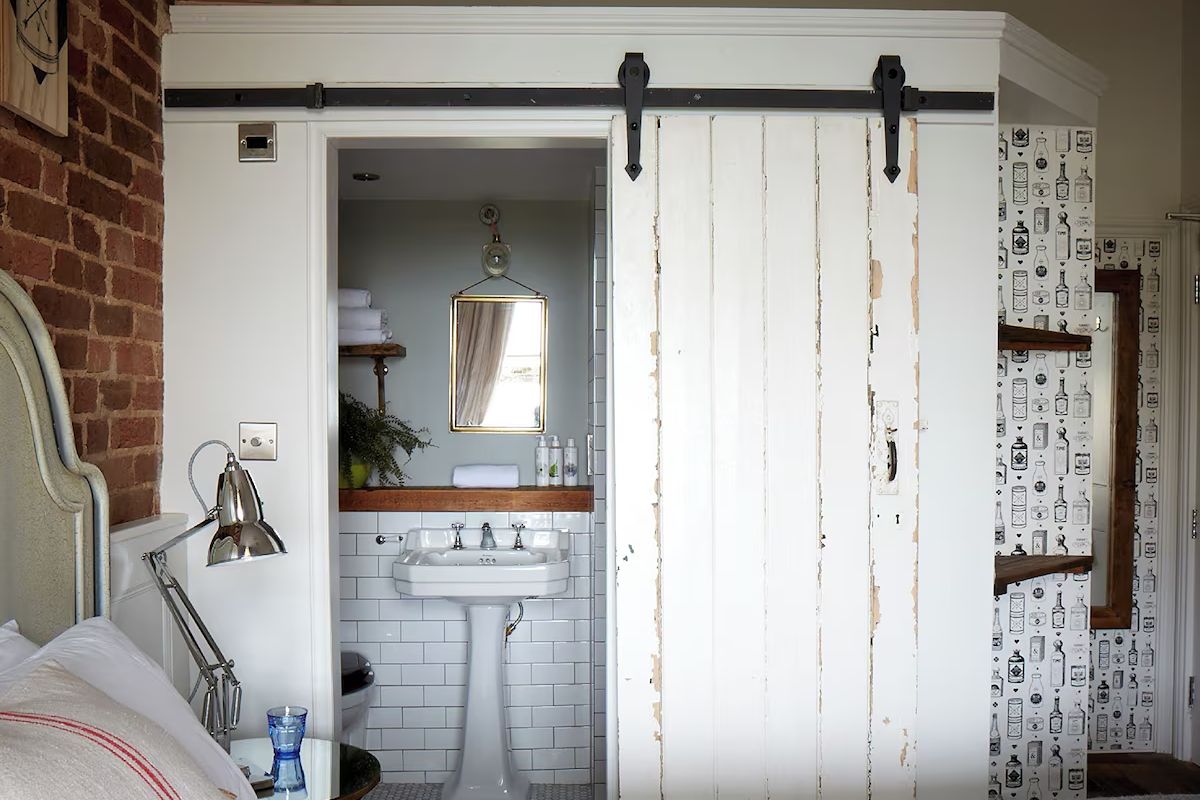 Characterful bedroom at Artist Residence Brighton, a quirky Brighton hen weekend hotel with exposed brick, playful wallpaper and an en-suite bathroom.
