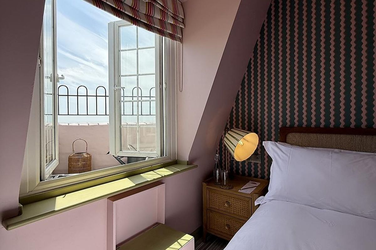 Bedroom at Drakes of Brighton, a boutique Brighton hen weekend hotel with striped wallpaper, soft pink tones and a bright window view.