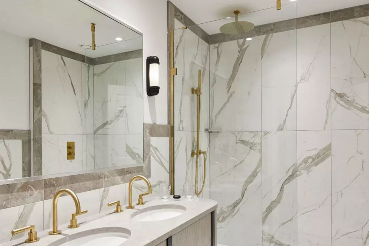 Luxury bathroom at The Grand Brighton, a stylish Brighton hen weekend hotel with marble-effect finishes, gold fittings and walk-in shower.