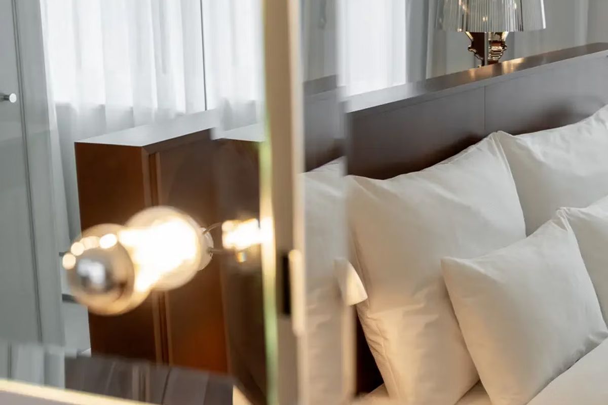 Close-up of a bright bedroom at Ruby Molly Hotel Dublin with crisp white bedding and warm contemporary lighting.