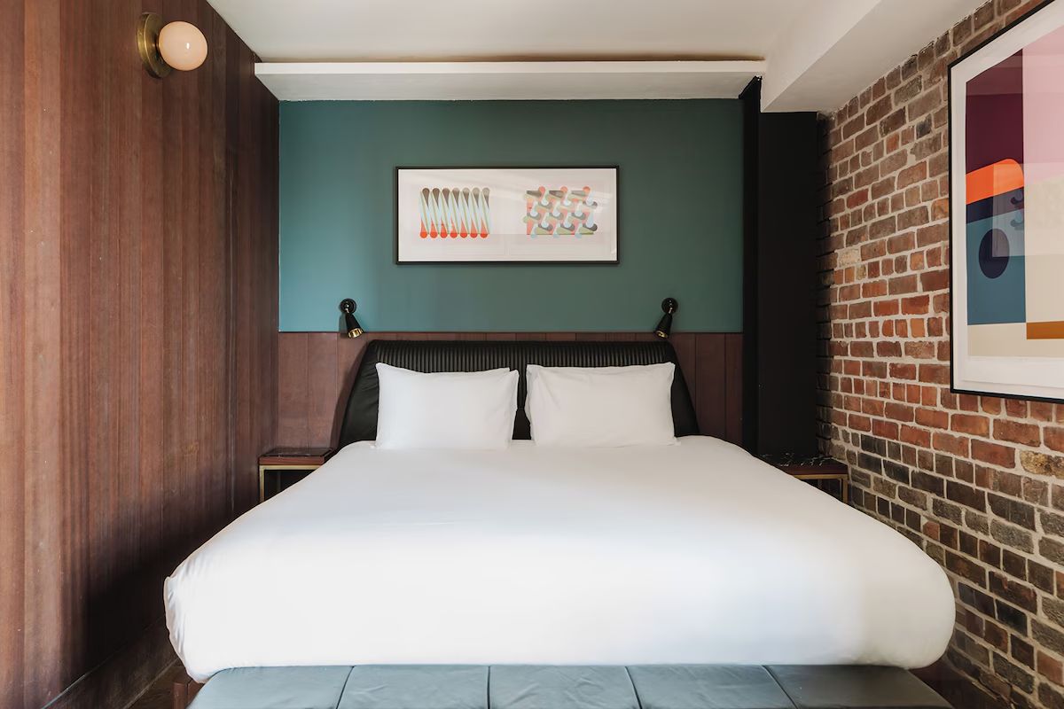 Double room at The Dean Docklands, stylish hen weekend accommodation in Dublin with exposed brick, teal walls and modern artwork.