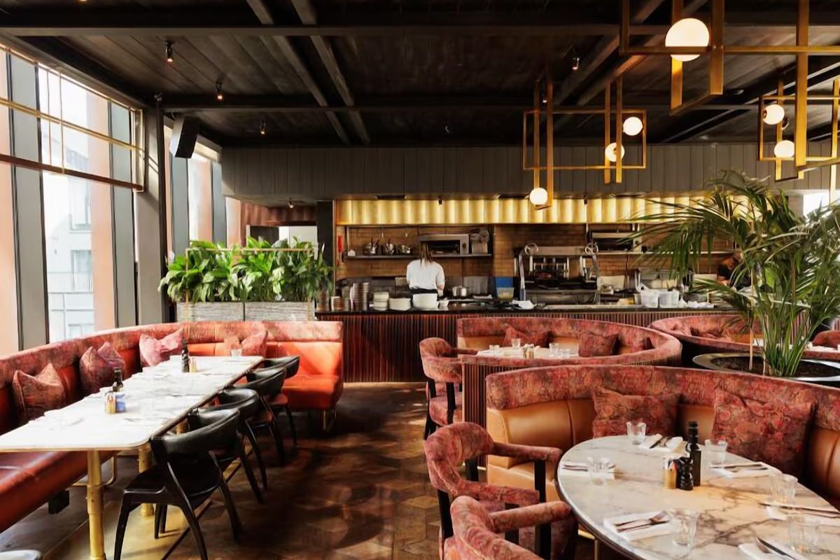 Restaurant at The Dean Docklands, a modern Dublin hen party hotel with plush booth seating, marble tables and an open kitchen.