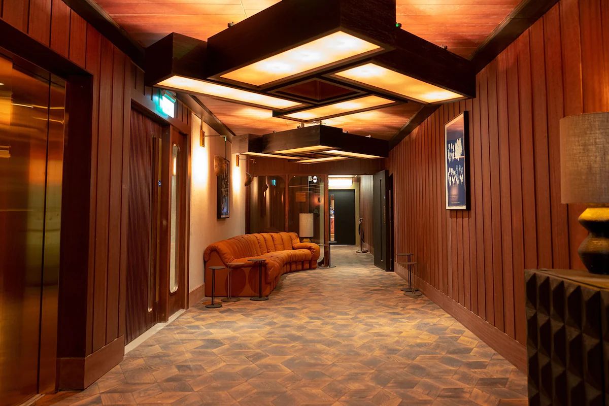 Hallway at The Dean Docklands, a stylish Dublin hen weekend hotel with warm wood panelling, statement lighting and retro seating.