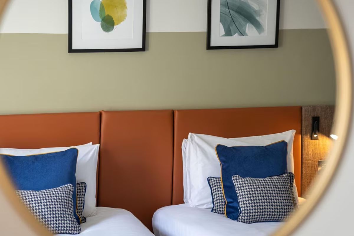 Twin bedroom detail at voco Edinburgh – Royal Terrace, an Edinburgh hen weekend hotel with warm leather accents, blue cushions and modern styling.